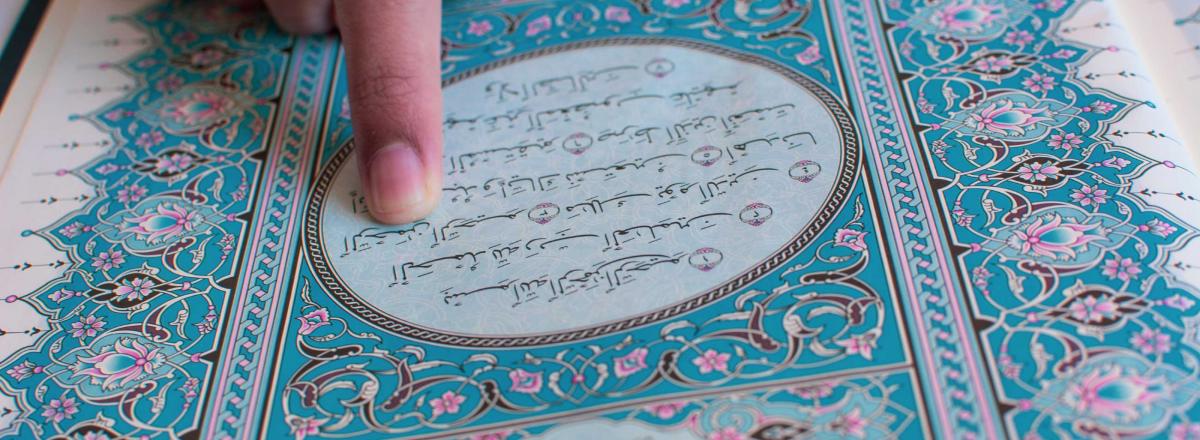 Finger zeigt auf Korantext